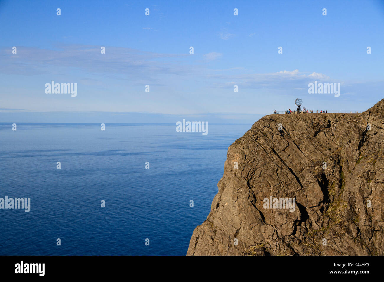 Les falaises au cap Nord cap nord en Norvège du Nord. avec le monde statue se profilant à l'horizon. Banque D'Images