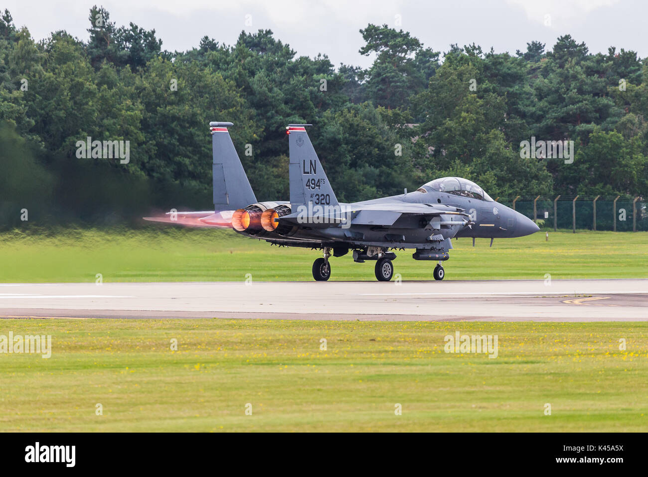 Un F-15E Strike Eagle de la 494e Escadron de chasse s'applique réchauffer qu'il décolle à RAF Lakenheath dans Suffolk sur une sortie de formation. Banque D'Images