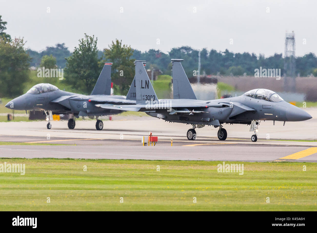 Une paire de F-15E forgé Blanche (à partir de la 48e Escadre de chasse) taxi sur la piste à RAF Lakenheath pour commencer une sortie d'entraînement au-dessus du ciel de l'UK. Banque D'Images
