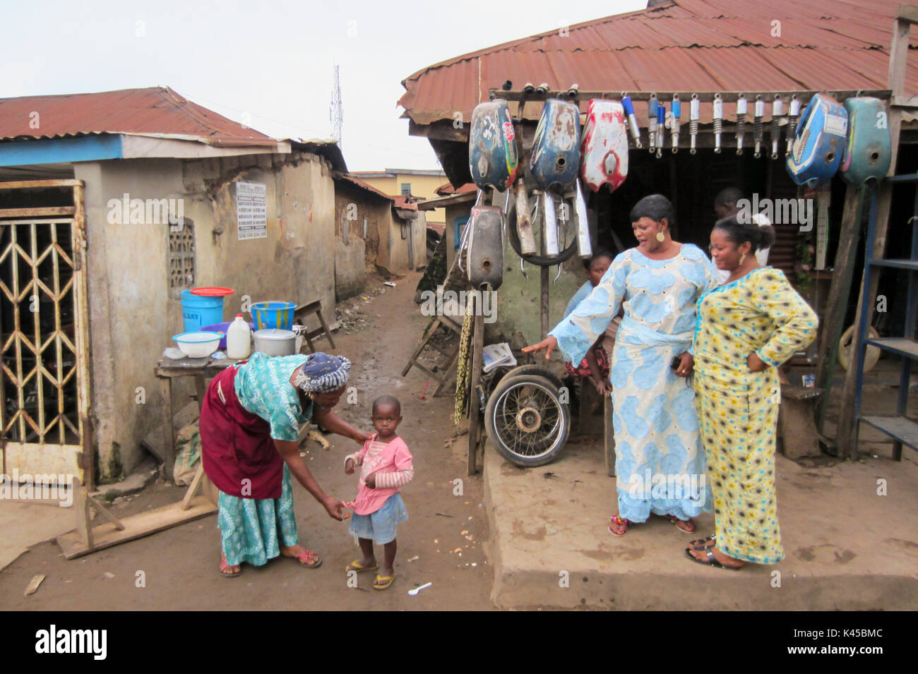 Femme et fille nigériane en face de pièces de rechange dans la ville de Segou, capitale de l'Etat d'Ondo au Nigeria Banque D'Images Femme et fille nigériane en face de pièces de rechange dans la ville de Segou, capitale de l'Etat d'Ondo au Nigeria Banque D'Images