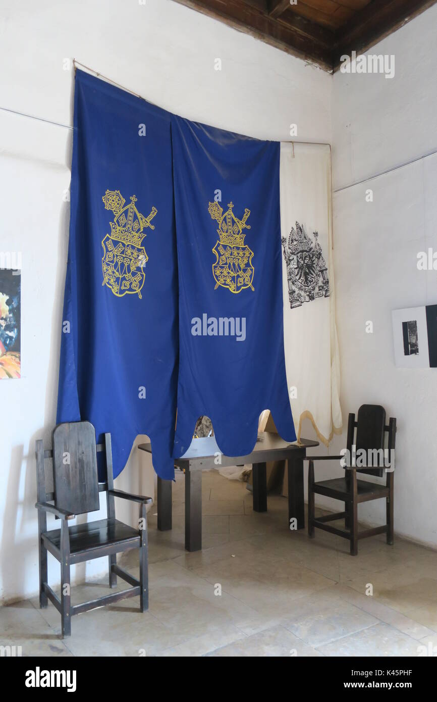 Intérieur du château, parc, vieille chaise en bois, beau drapeau bleu avec les armoiries de la ville, les peintures sur le mur en Hunedoara, Roumanie. Banque D'Images