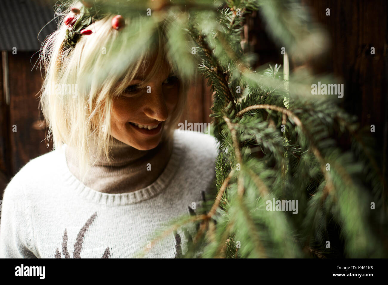 Femme blonde, coiffe, Garland avec églantier, les rameaux des arbres à feuillage persistant pour la décoration, portrait Banque D'Images