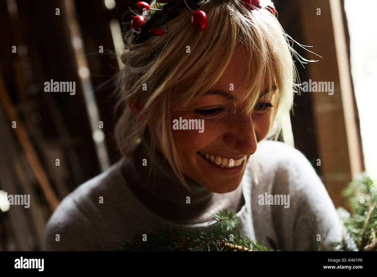 Femme blonde, coiffe, Garland avec églantier, les rameaux des arbres à feuillage persistant pour la décoration, sourire, portrait Banque D'Images