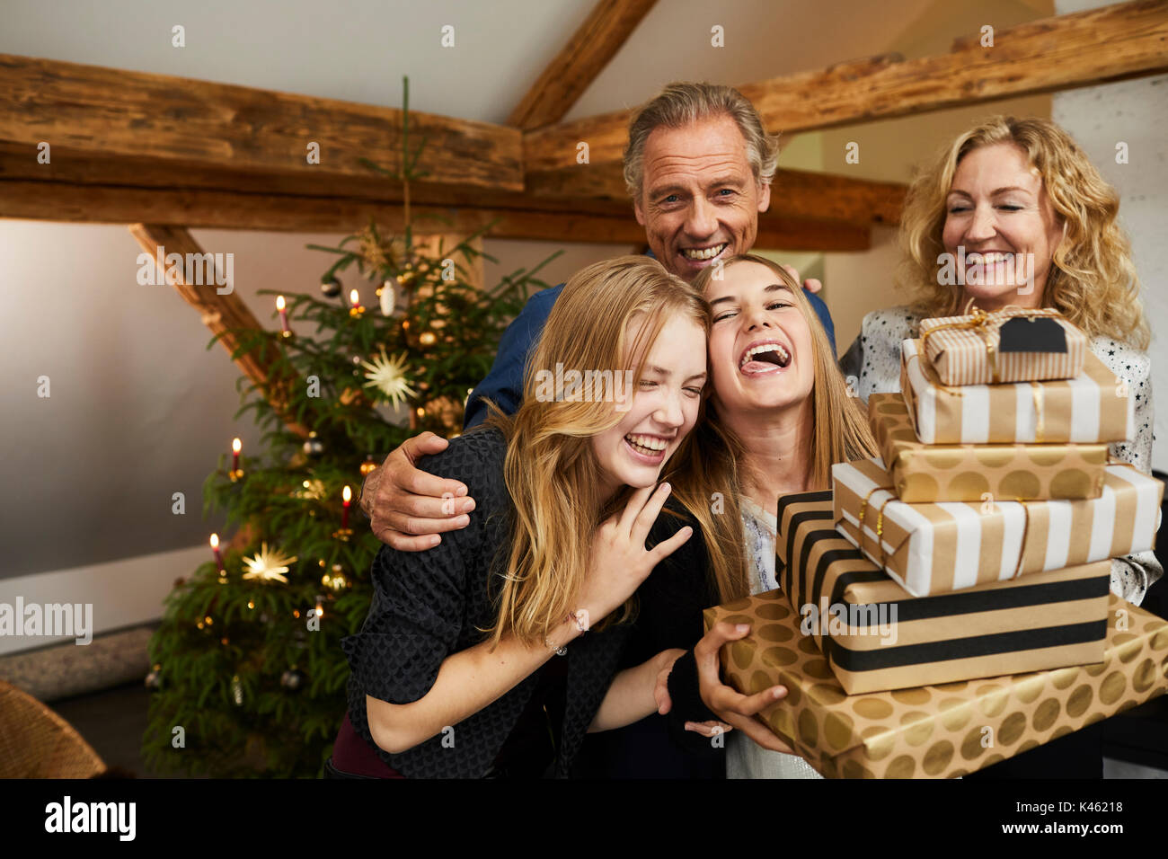 Les parents et leurs filles avec présente en face d'arbre de Noël, la moitié portrait Banque D'Images