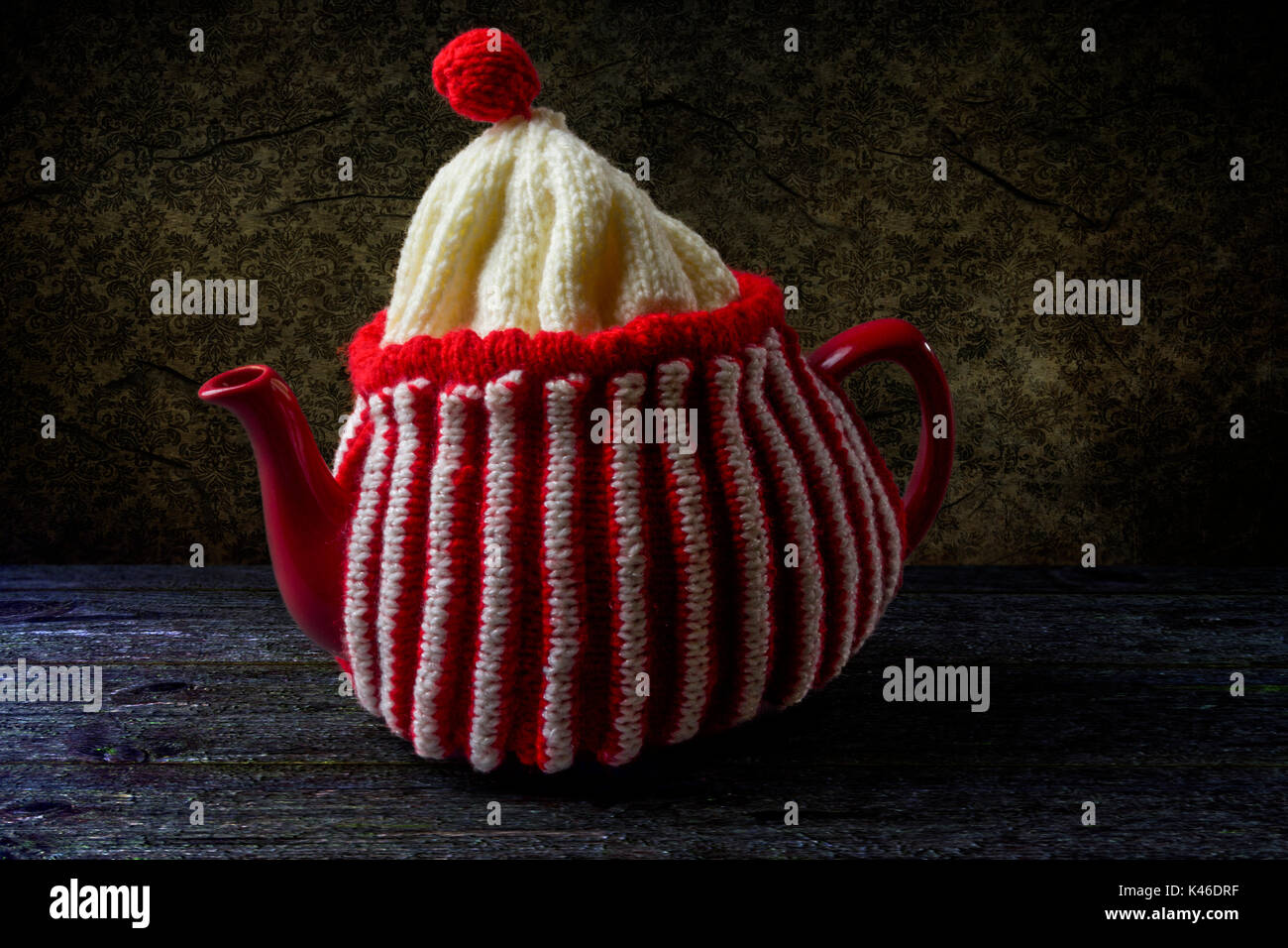 La chine rouge théière avec un rouge et blanc à rayures en laine tricoté théière Banque D'Images