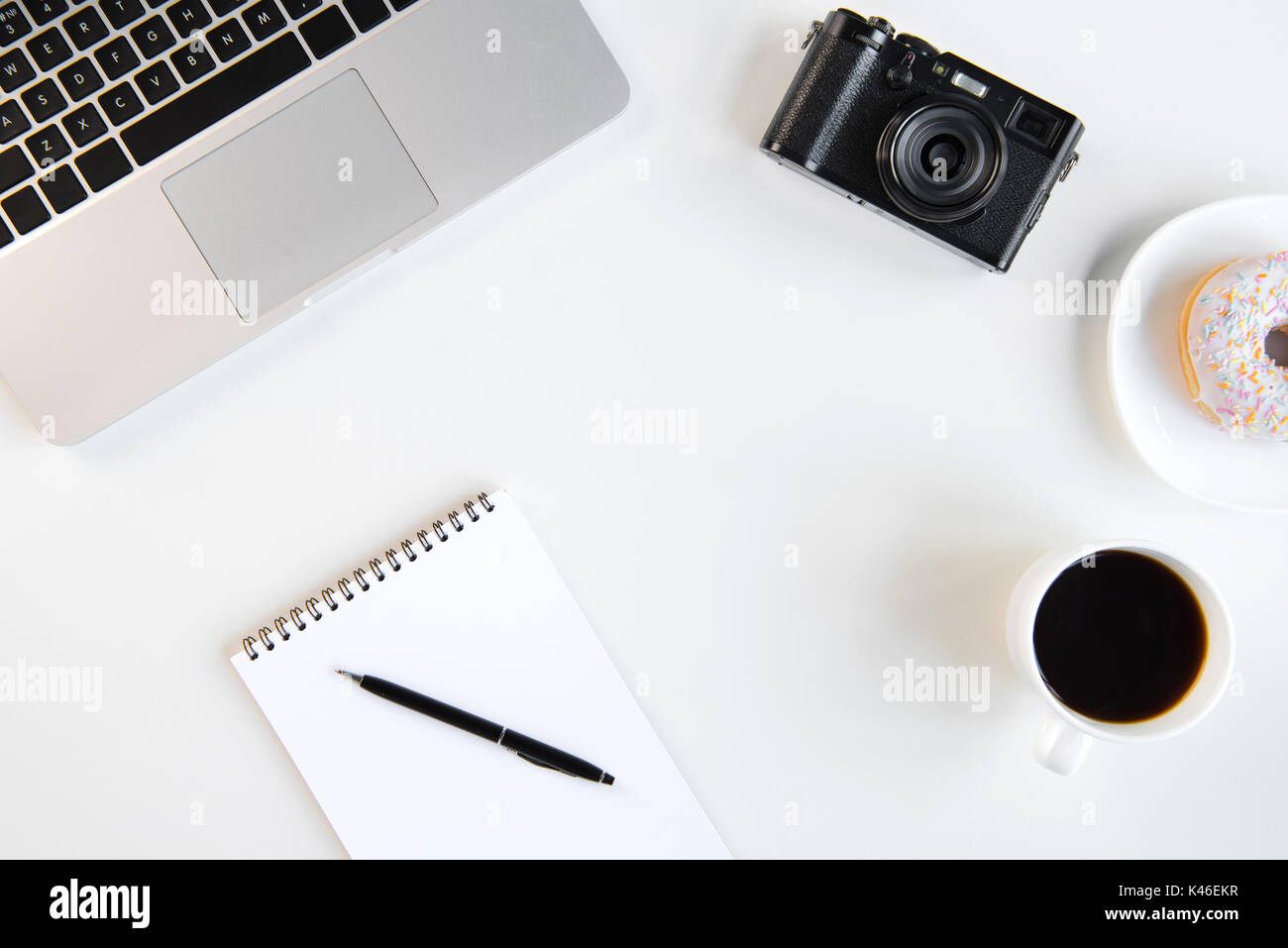 Vue de dessus de l'ordinateur portable, ordinateur portable blanc avec un stylo, tasse de café et de la caméra sur le lieu de travail Banque D'Images