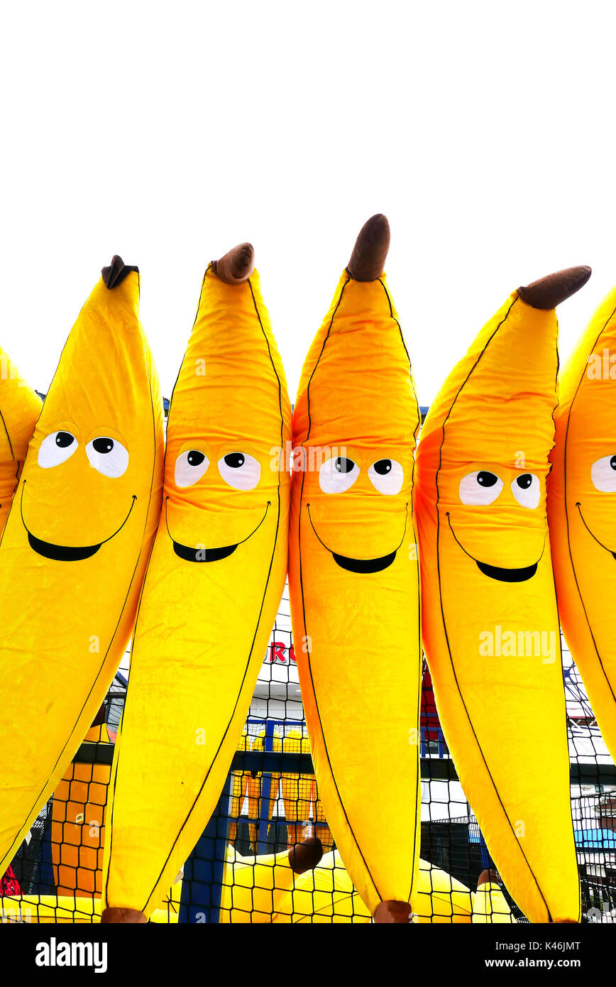 Bananes géantes gonflables avec des visages souriants sur un stand de jouets, Blackpool Pleasure Beach Banque D'Images
