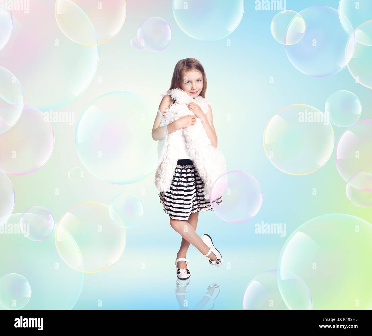 Petite fille avec de grandes bulles de savon. Banque D'Images