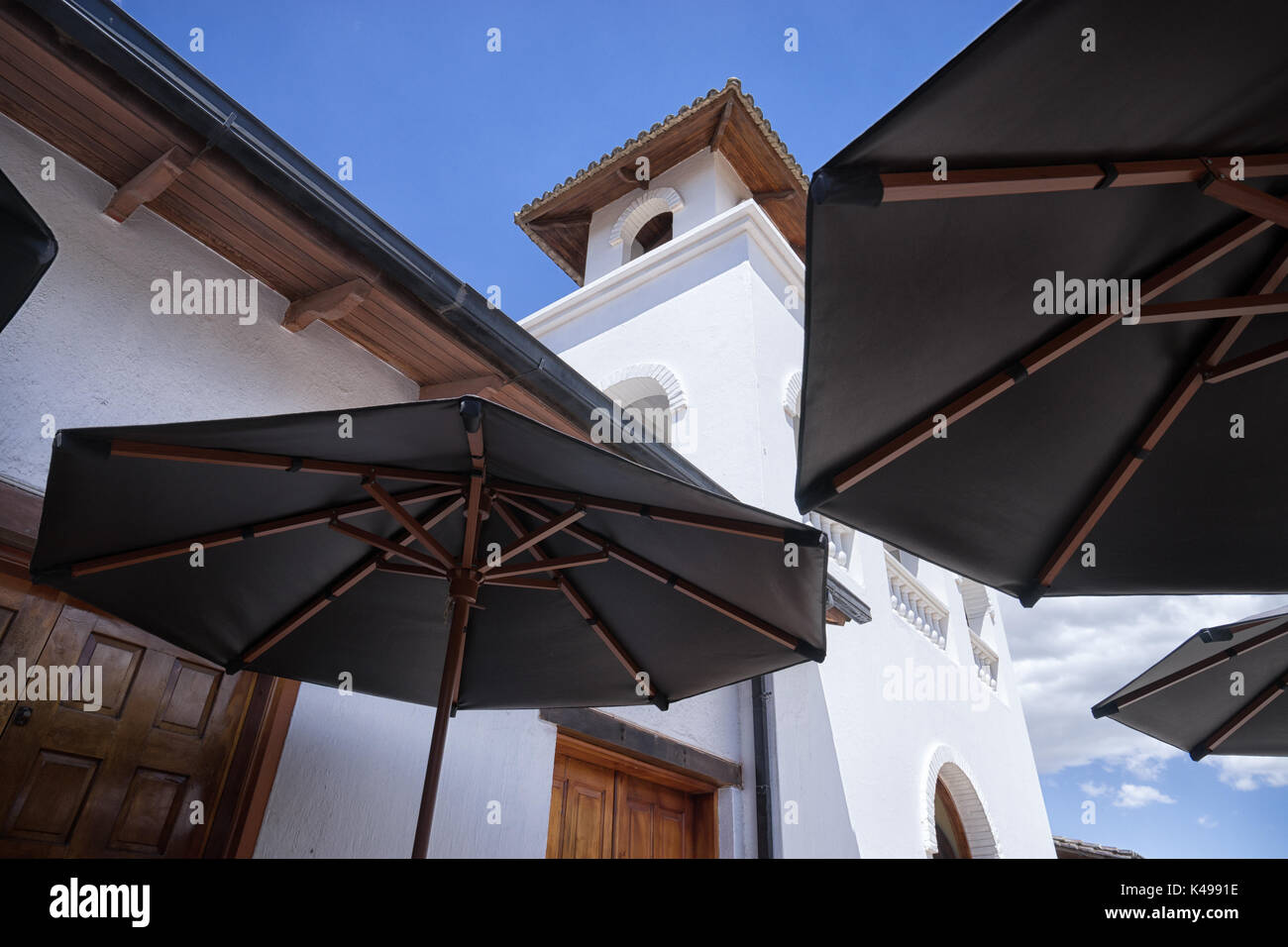 1 août, 2016 Quito, Equateur : colonial blanc bâtiment vu entre patio parasols à la Mitad del Mundo monument Banque D'Images