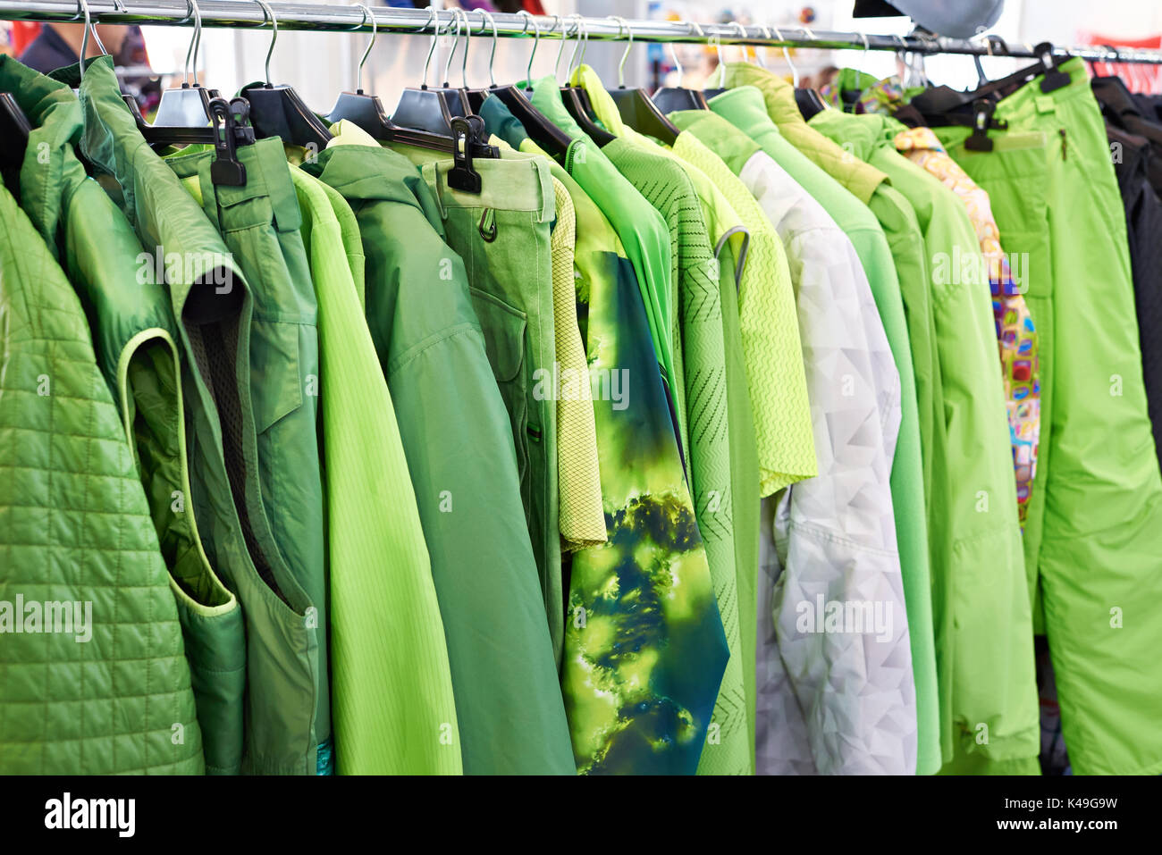 Vestes, gilets et des vêtements de pluie sur un cintre dans le magasin Banque D'Images
