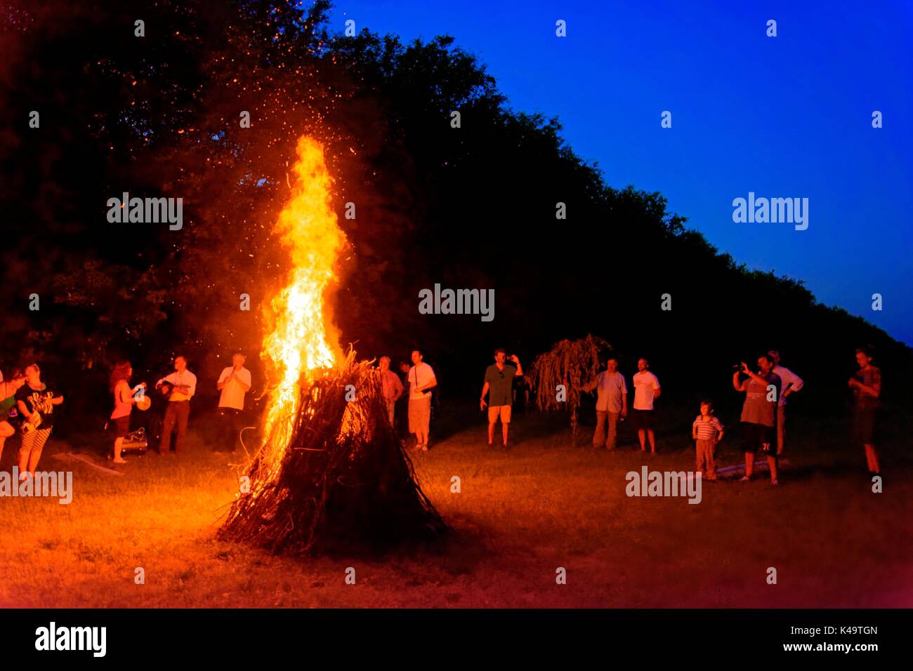 Les gens entourent le feu de jour de St. John S. Banque D'Images