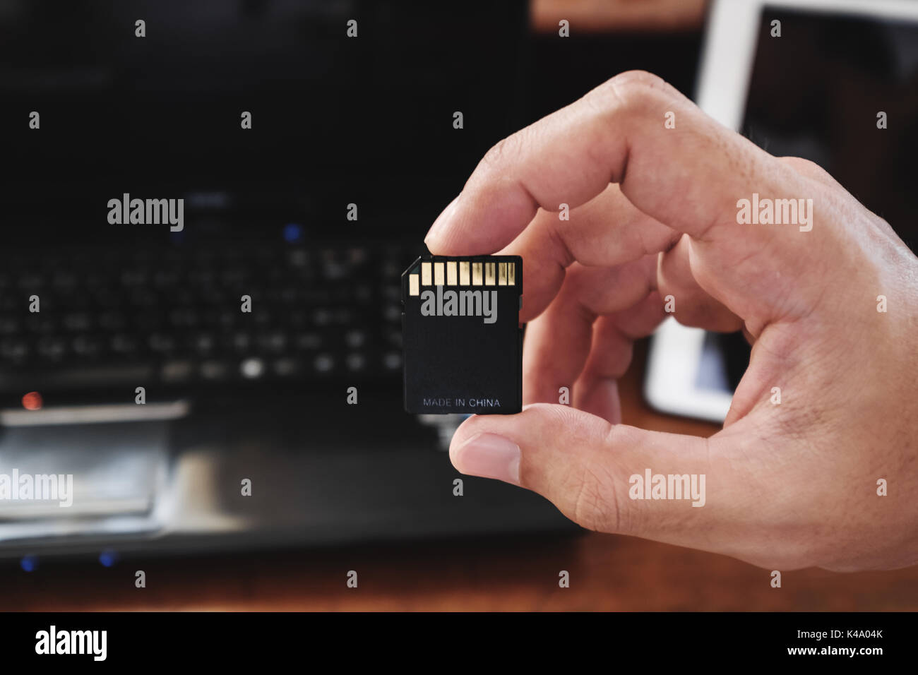 Close-up main tenant la carte mémoire, la technologie produit fabriqué en Chine. Banque D'Images