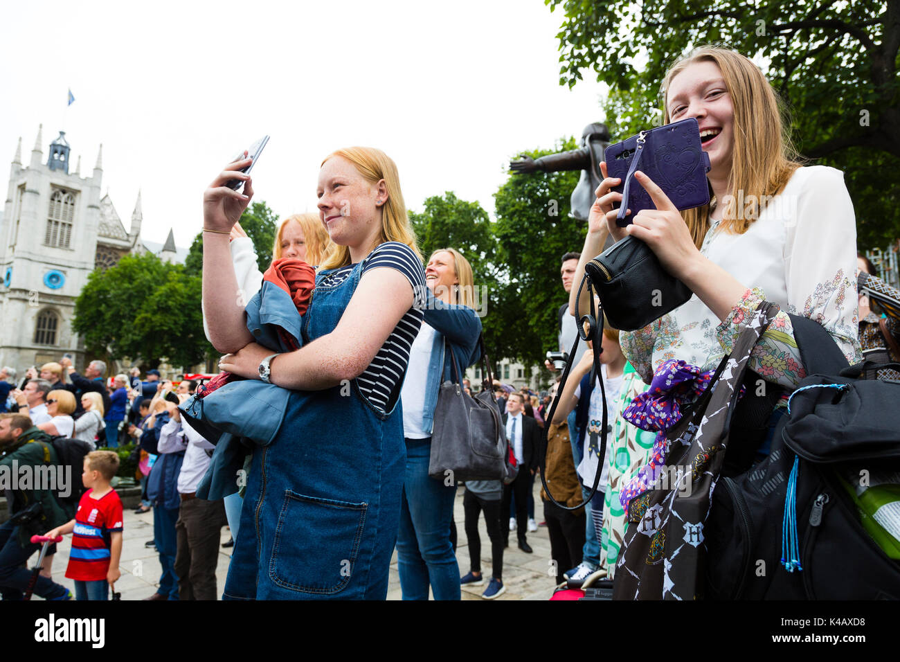 Londres, Royaume-Uni. Les jeunes filles rient et qu'elle photographie Big Ben qu'il sonne sa dernière bongs pendant quatre ans. Banque D'Images