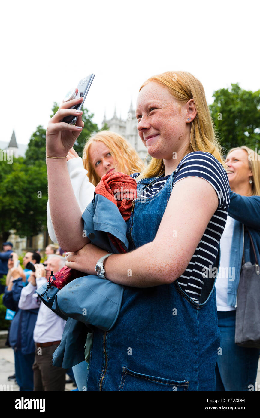 Londres, Royaume-Uni. Une adolescente rit comme elle photographie des Big Ben qu'il sonne sa dernière bongs pendant quatre ans. Banque D'Images