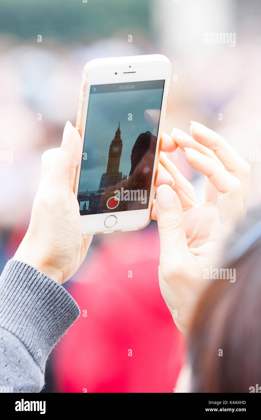 Londres, Royaume-Uni. Une femme prend une photo à l'aide d'un iPhone que Big Ben sonne sa dernière bongs pendant quatre ans. Banque D'Images