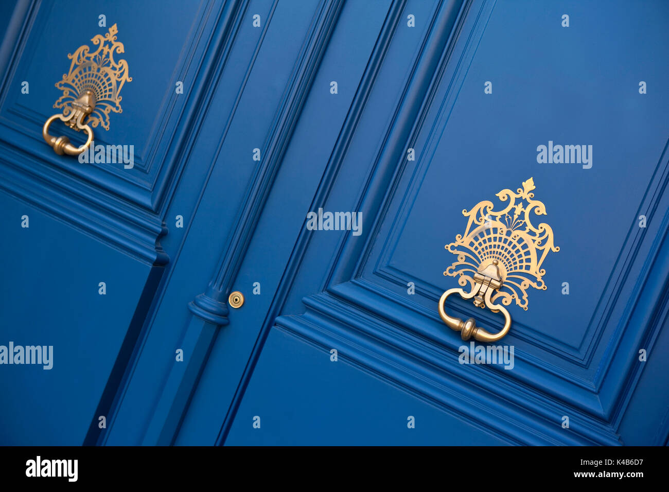 Heurtoirs fer forgé sur une porte en bois bleu d'un hôtel particulier Français Banque D'Images