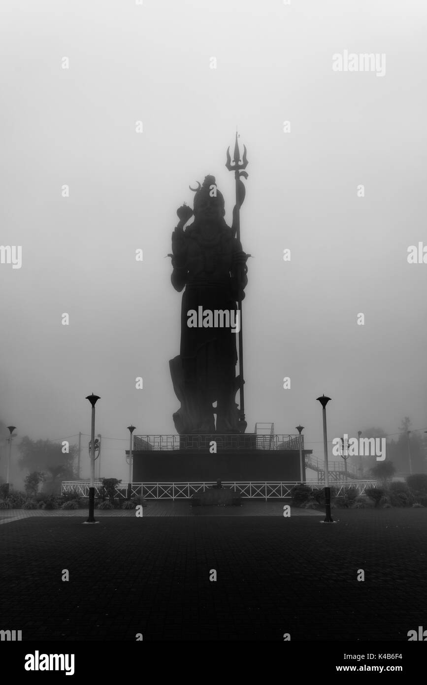 Photo en noir et blanc, tourné en une journée avec le brouillard pour créer un sentiment mystique, une statue de seigneur Shiva (Mangal Mahadev) à Grand Bassin à l'île Maurice. Banque D'Images