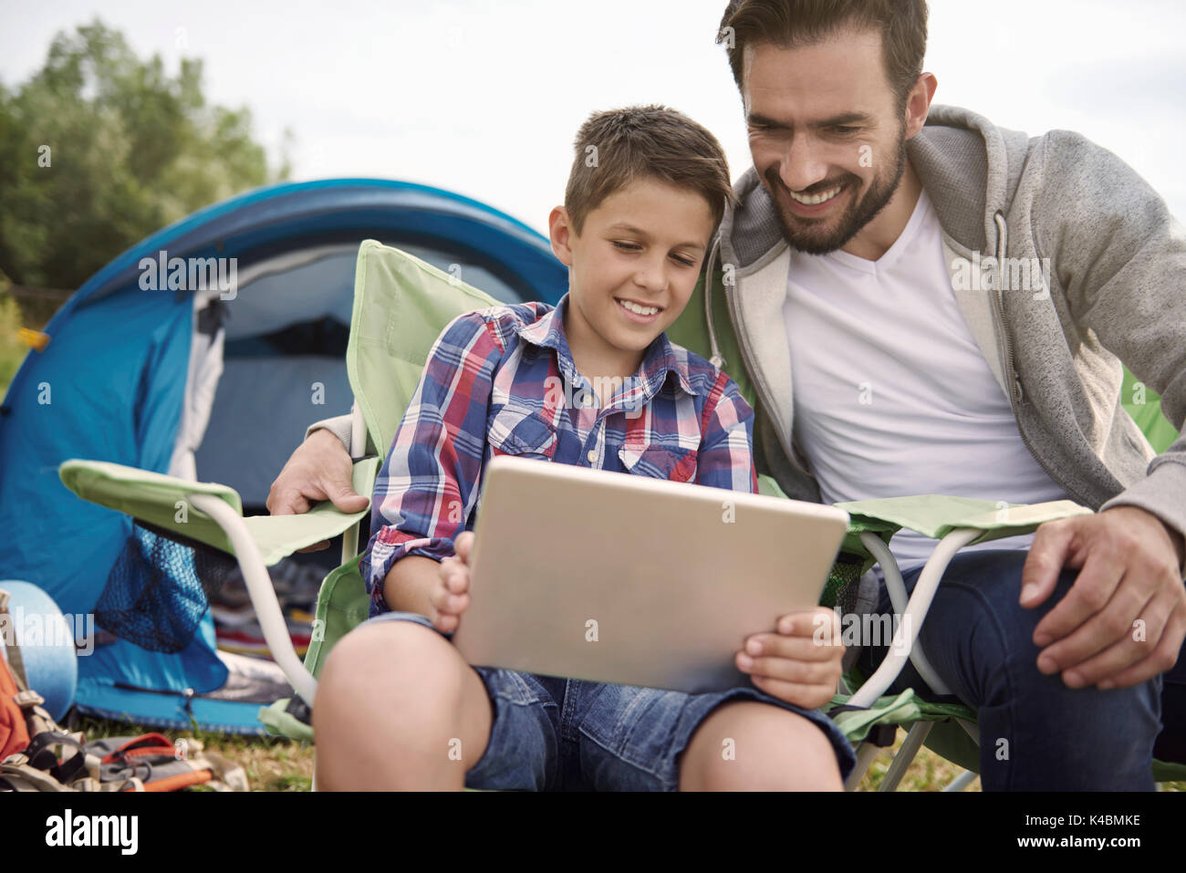 Père et fils la navigation Internet sur camping Banque D'Images
