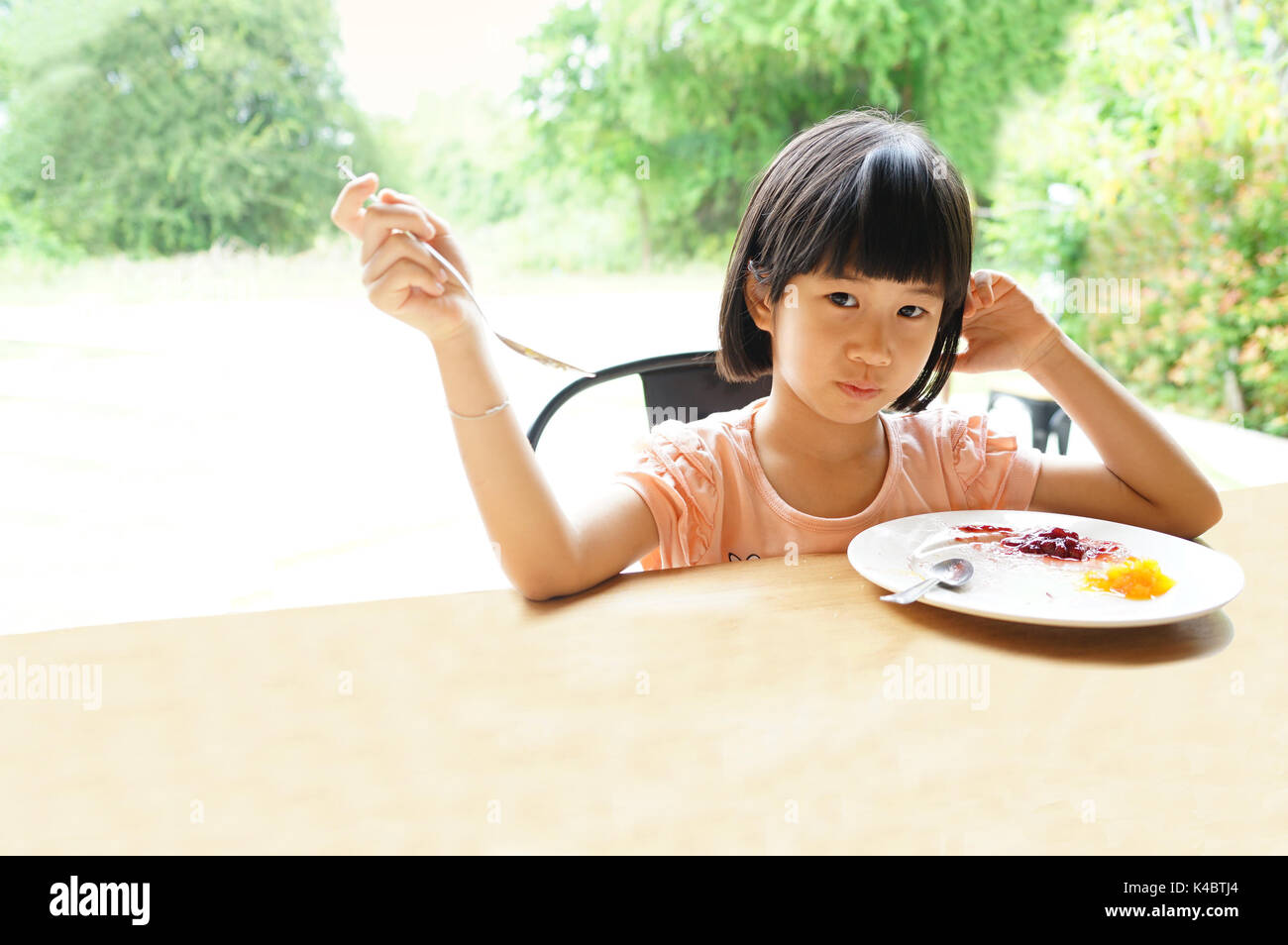 Asian girl 6s manger des repas Petit déjeuner assis dans le tableau de la plaque Banque D'Images