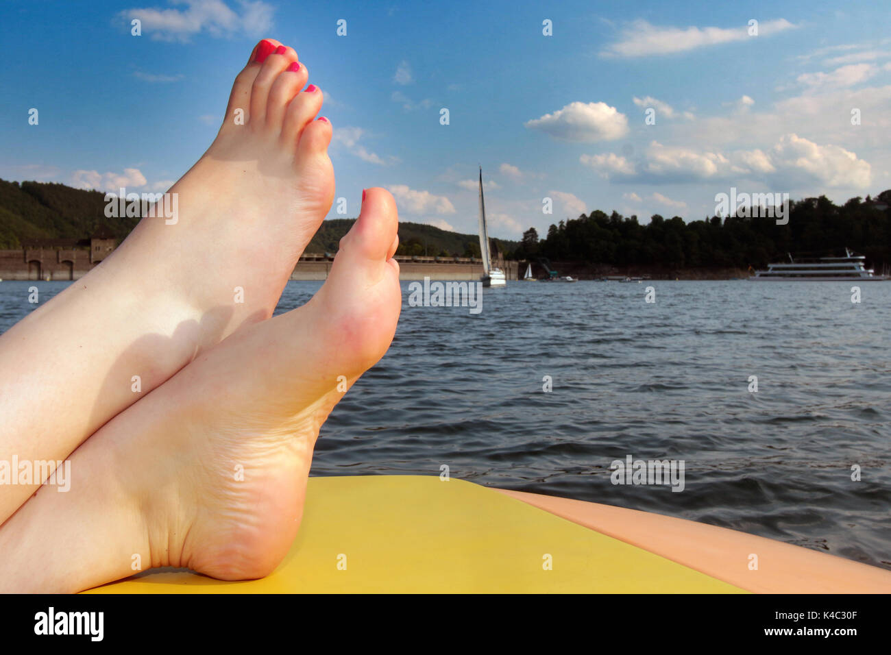 Femme barefootée se détendant sur Edersee Banque D'Images