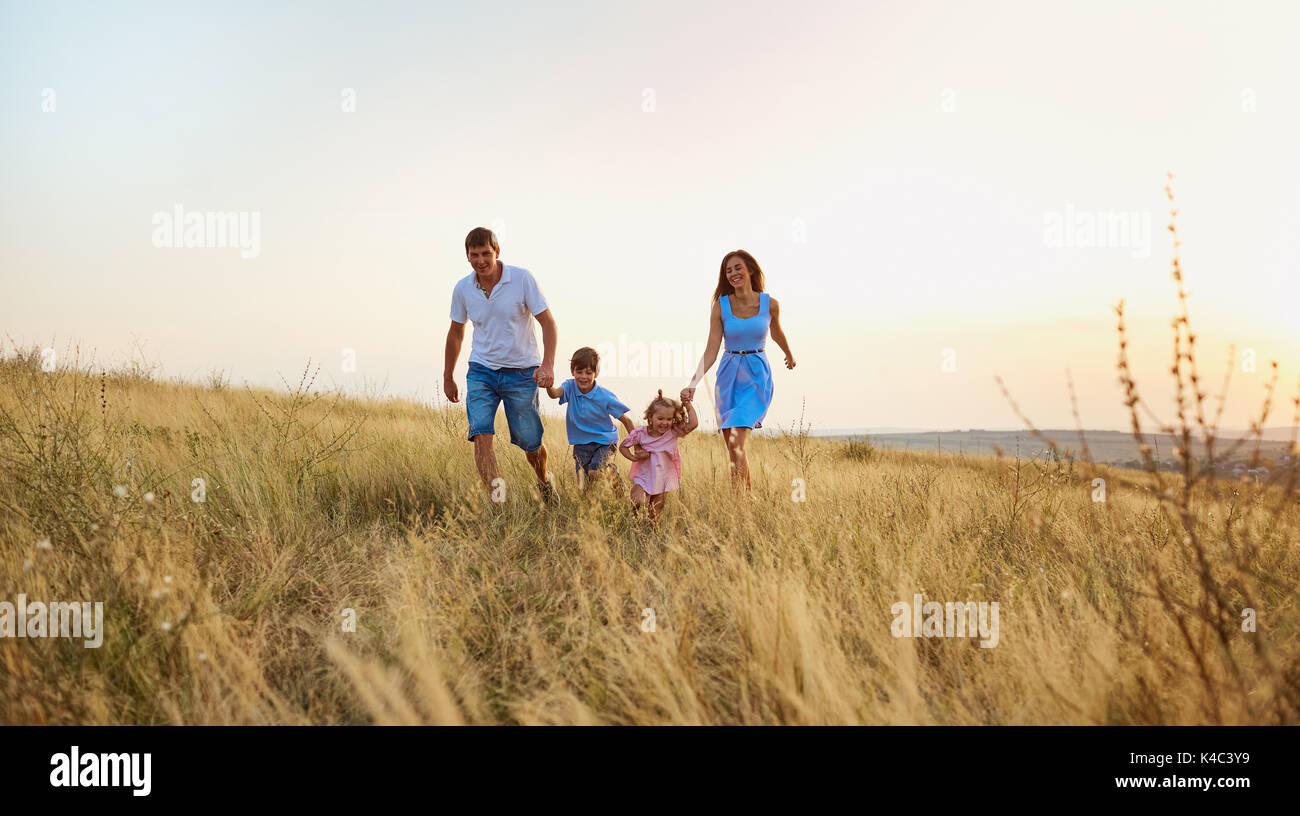 Famille heureuse de jouer sur la nature en été. Banque D'Images