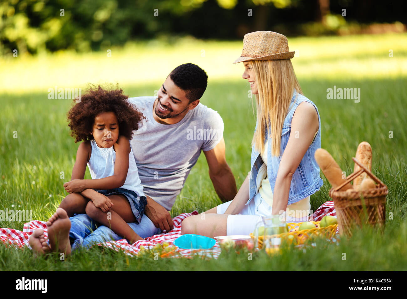 Offensé petite fille assise avec les parents sur l'aire de pique-nique Banque D'Images