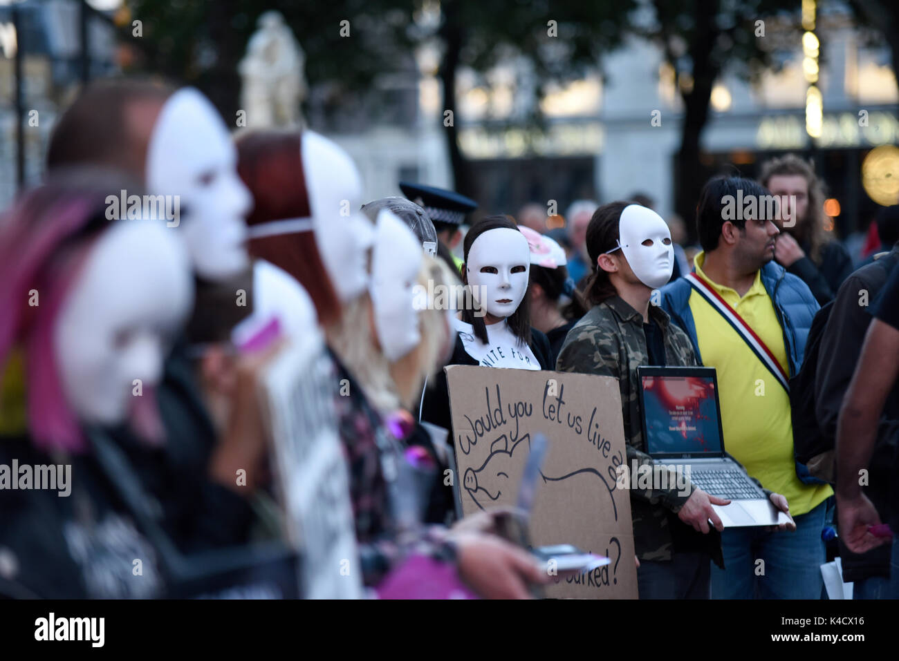 Les Terriens de l'expérience des défenseurs des droits des animaux qui protestaient devant Burger King à Leicester Square, Londres. Les manifestants portant des masques anonymes Banque D'Images