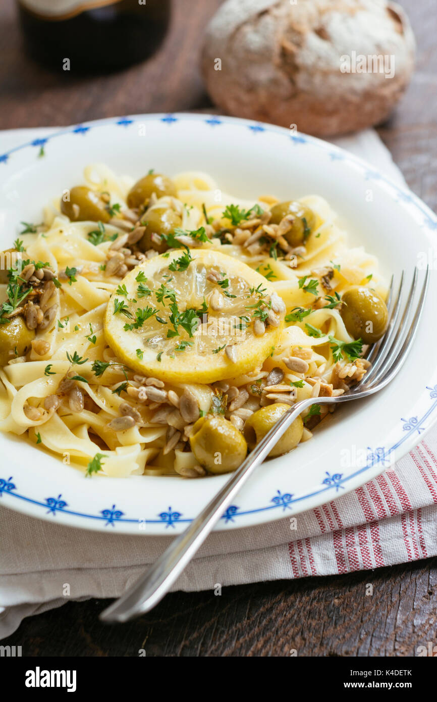 Tagliatelles au citron de Sicile, de l'ail et les olives, garnie de graines de tournesol. Banque D'Images