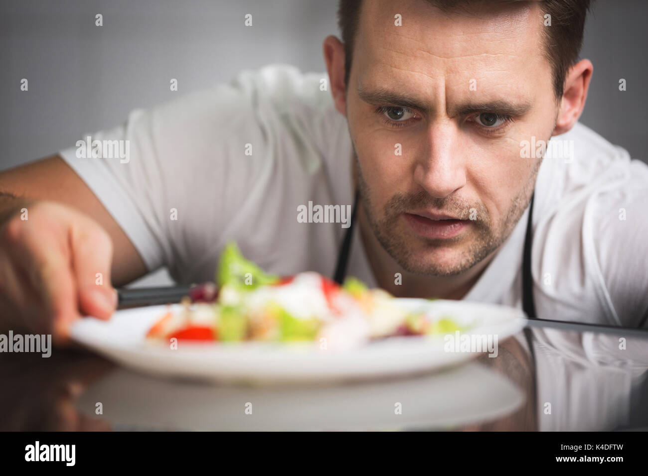 Close up portrait avant de male chef preparing salad Banque D'Images