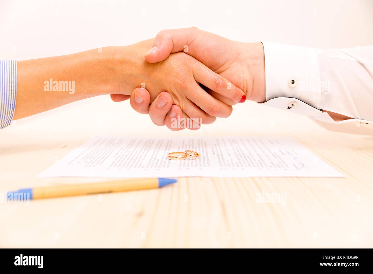 Libre d'un jeune homme d'une une jeune femme se serrer la main après avoir signé un accord prenuptial Banque D'Images