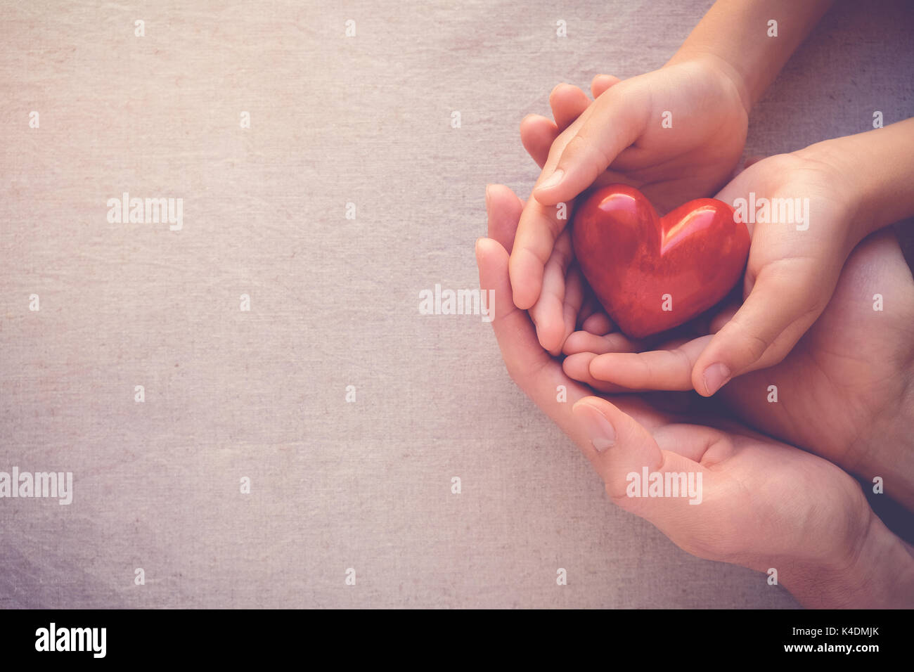 Adulte et enfant mains holiding cœur rouge, les soins de l'amour et de la famille concept Banque D'Images