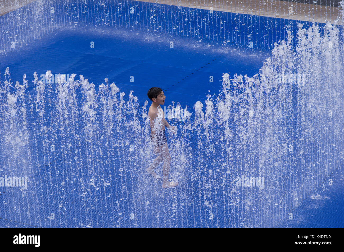 Heureux Garçon jouant à l'extérieur dans une fontaine au southbank centre, dans le sud de Londres, UK Banque D'Images