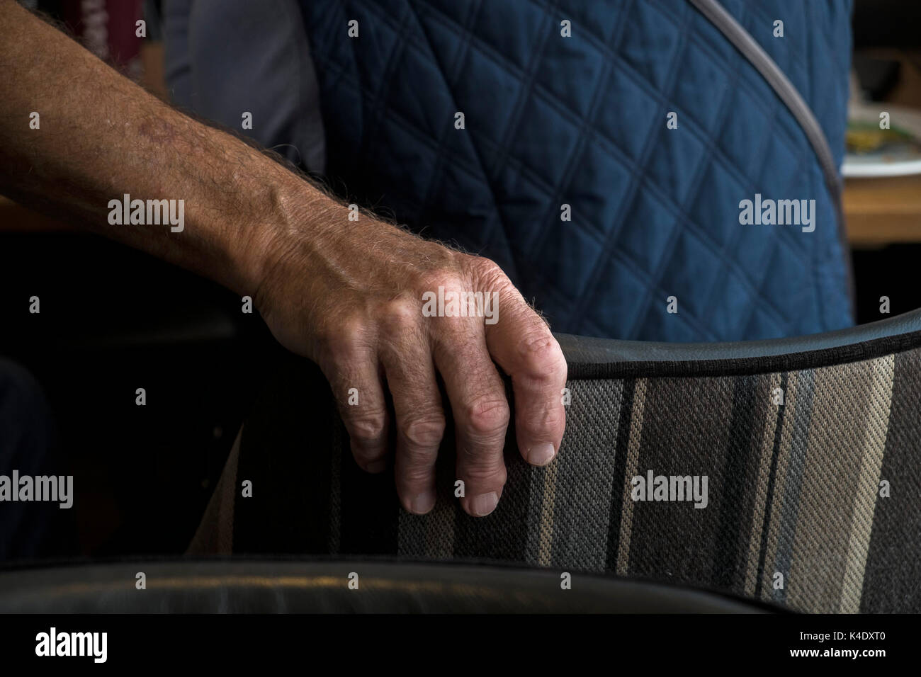 Âge - la main d'une personne âgée tenant le dos d'une chaise. Banque D'Images