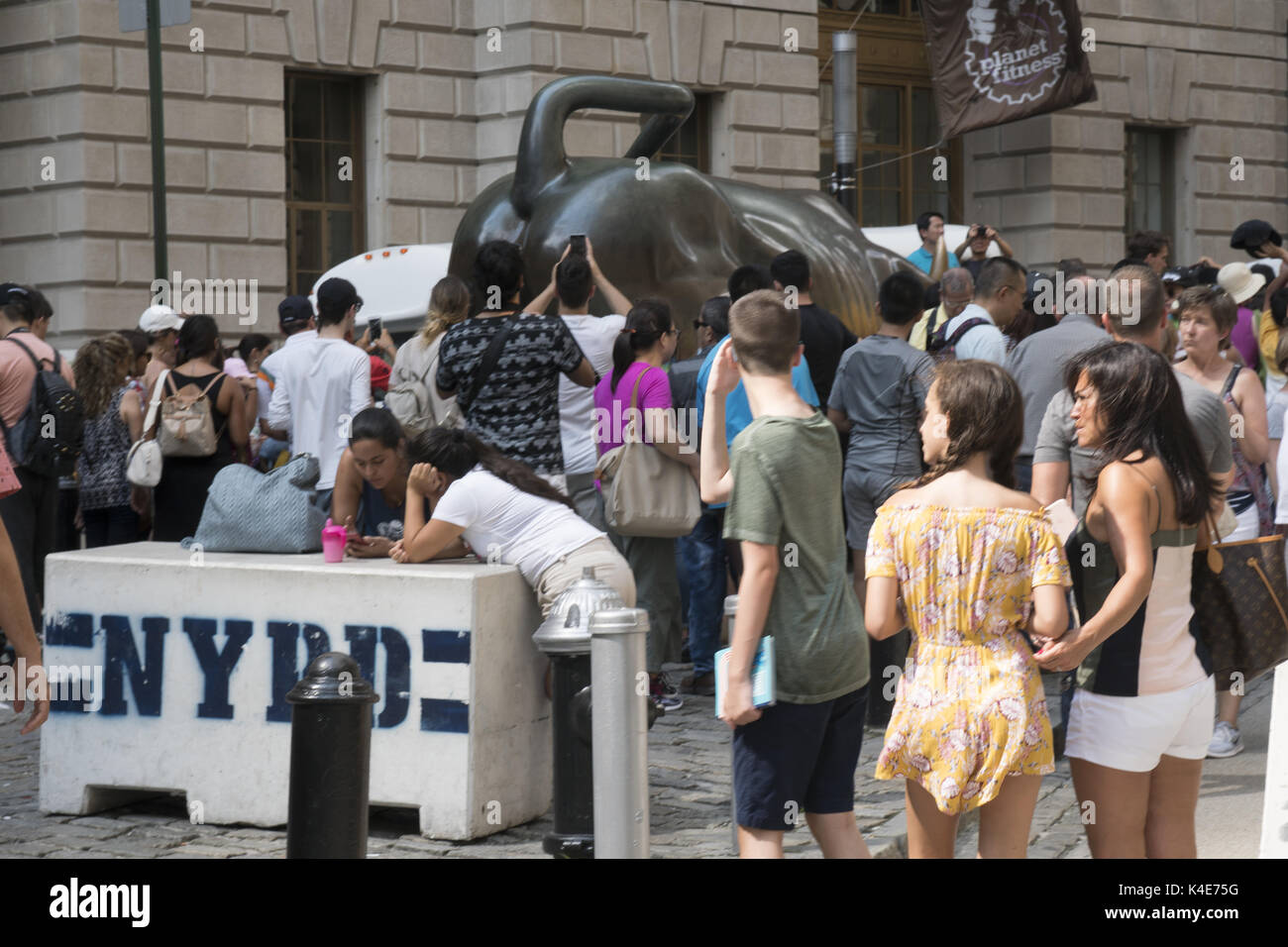 Le célèbre taureau de charge à la pointe sud de Broadway dans le Financial District est toujours entouré de personnes pour une photo op. Manhattan, New York. Banque D'Images