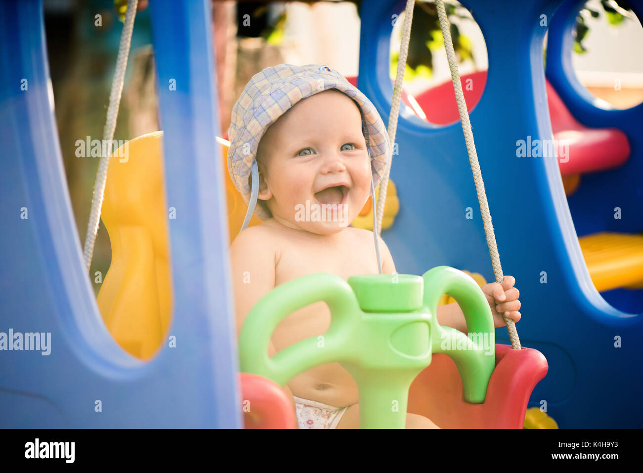 Happy baby girl s'amusant sur une balançoire Banque D'Images