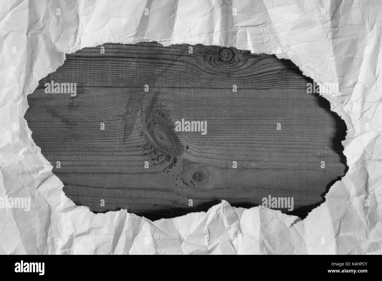 Papier blanc froissé déchiré trou situé sur la planche de bois brun vide avec copyspace. gris et blanc. Banque D'Images