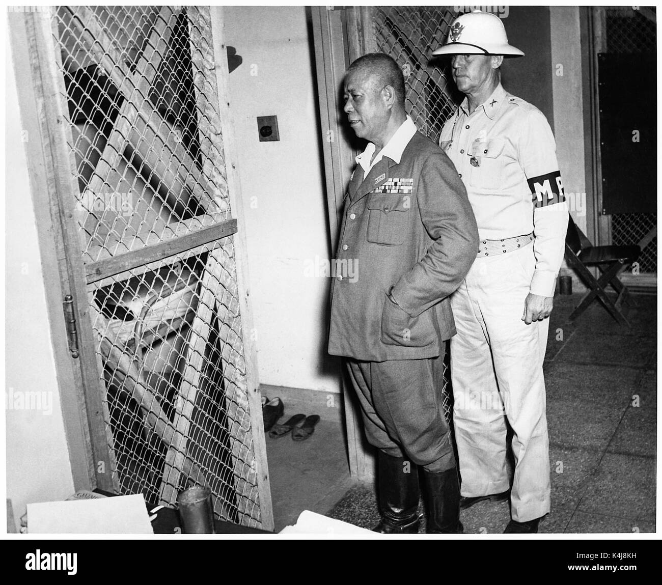 Tomoyuki Yamashita (1885-1946) aussi connu comme 'Le Tigre de Malaisie", général de l'Armée impériale japonaise pendant la Seconde Guerre mondiale qui ont envahi les possessions britanniques de Malaisie et Singapour. Du 29 octobre au 7 décembre 1945, un tribunal militaire américain à Manille a essayé général Yamashita pour crimes de guerre liés à la massacre de Manille et de nombreuses atrocités dans les Philippines et Singapour. La cour a conclu Yamashita a été reconnu coupable et condamné à mort. Photographie prise le 1 novembre 1945, retourné dans sa cellule, escorté par le Major A.S. 'Jack' Kenworthy pendant son procès pour crimes de guerre. Banque D'Images