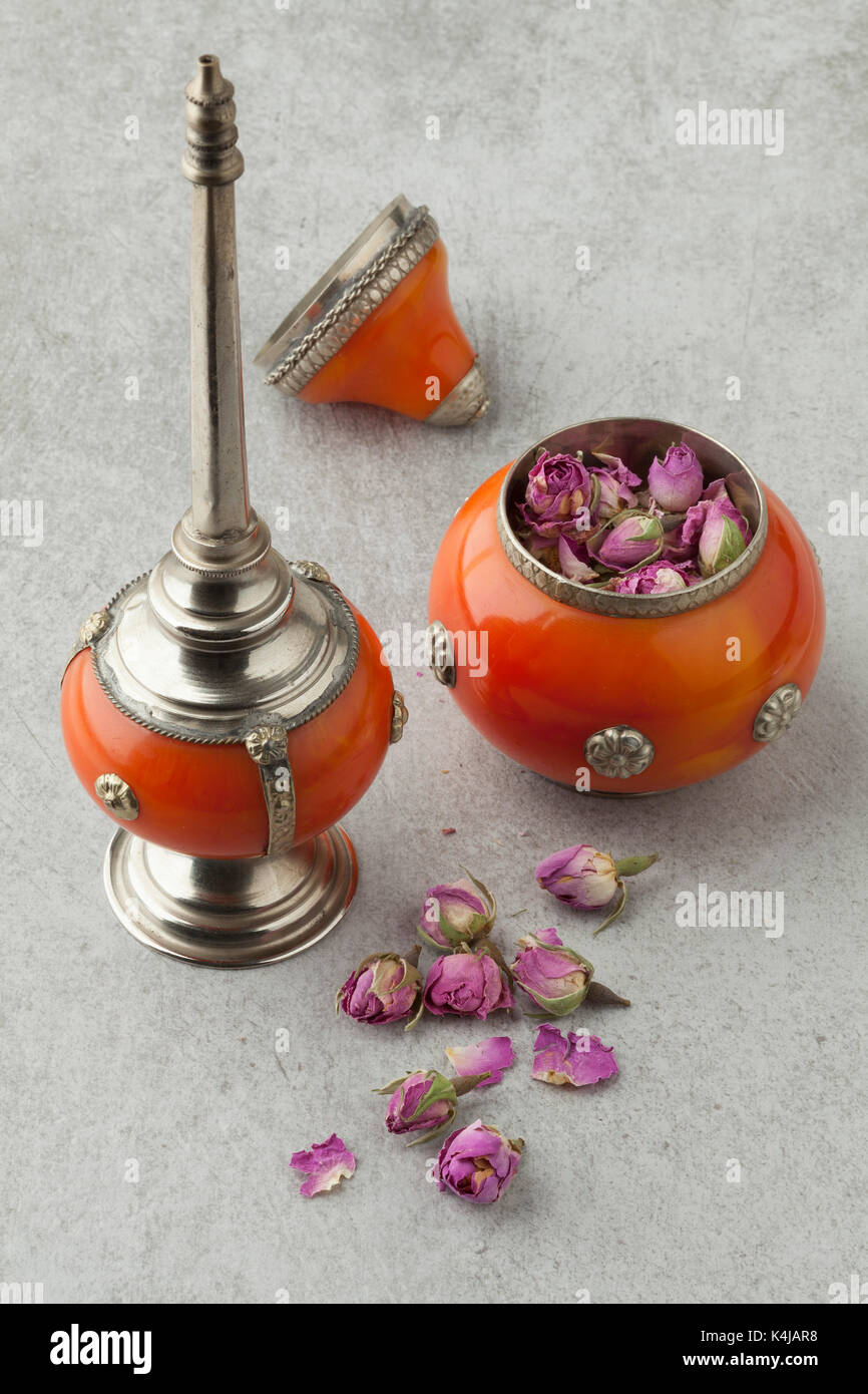 Boutons de rose séchés dans un bol marocain pour utilisation à saupoudrer l'eau de rose Banque D'Images