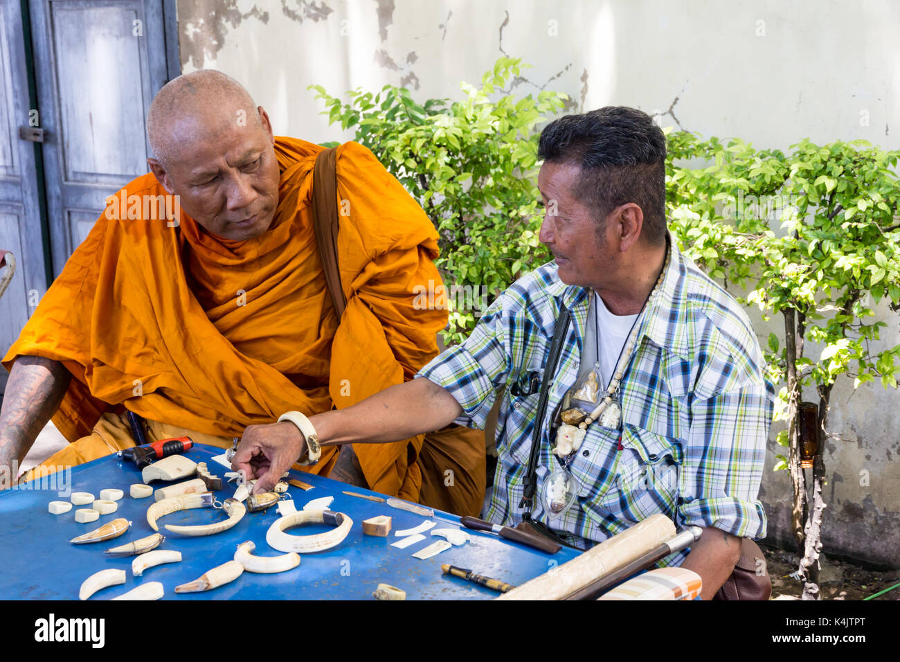 Moine bouddhiste thaï amulettes discuter avec un vendeur, Bangkok, Thaïlande Banque D'Images