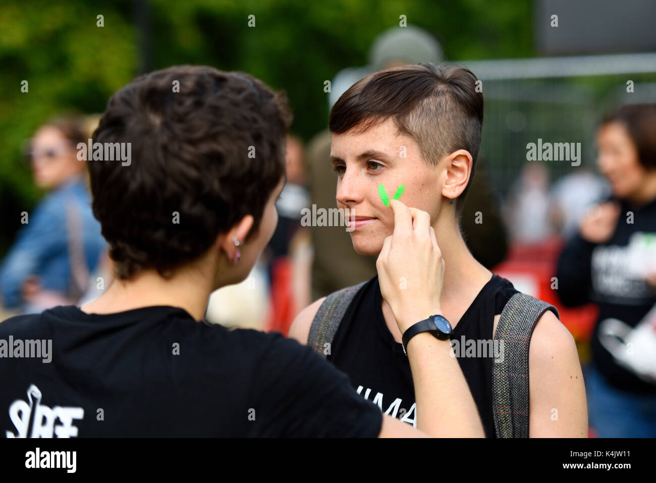 Les défenseurs des droits des animaux pour préparer une manifestation pour promouvoir le mode de vie végétalien. Hyde Park, Londres. V pour la peinture sur le visage de fille vegan Banque D'Images