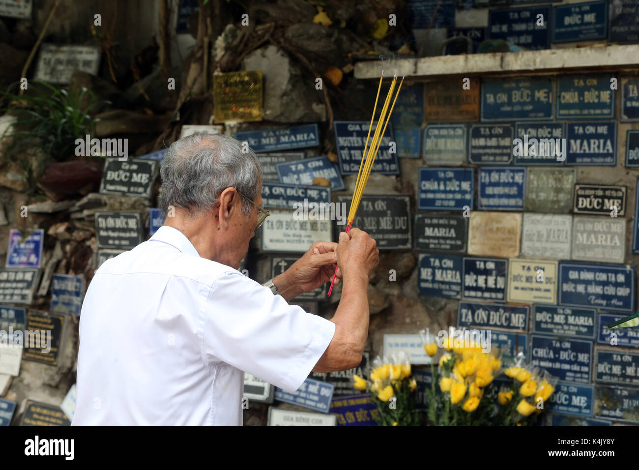 Homme priant en copie de la grotte de Massabielle, église Saint-Philippe (église Huyen Sy), Ho Chi Minh ville, Vietnam, Indochine, Asie du Sud-est, Asie Banque D'Images