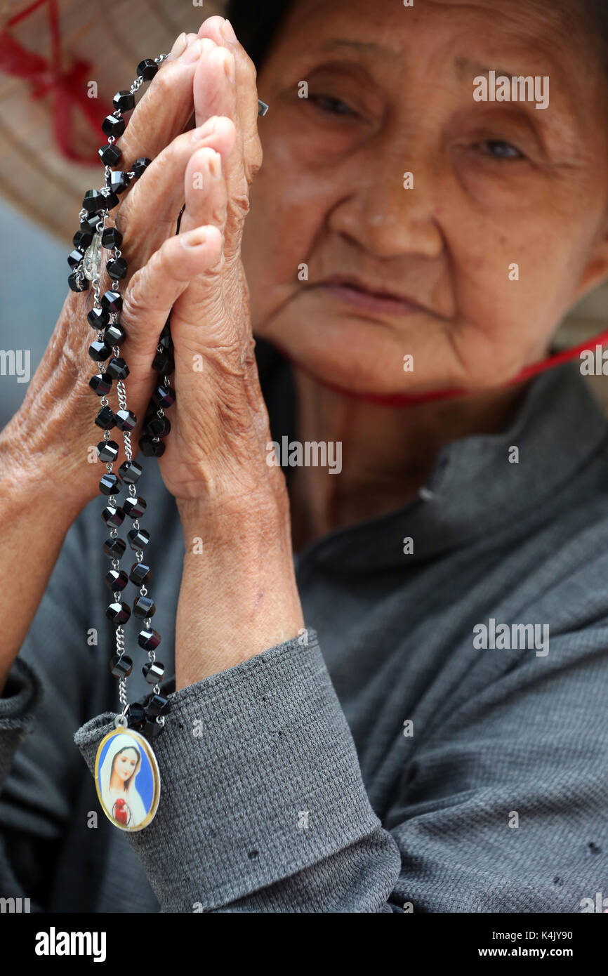 Vieille femme vietnamienne en prière avec le chapelet, église st. Philip huyen sy (église), Ho Chi Minh City, Vietnam, Indochine, Asie du sud-est, l'Asie Banque D'Images