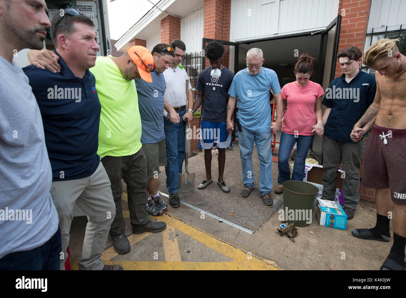 Beaumont, Texas USA sept. 5, 2017 : congrégation membres et bénévoles Inscrivez-vous dans la prière à l'extérieur de l'église baptiste missionnaire magnolia après le nettoyage des installations inondées dans le centre-ville de Beaumont. La région est encore du mal à se remettre de l'ouragan Harvey il y a presque deux semaines. crédit : bob daemmrich/Alamy live news Banque D'Images