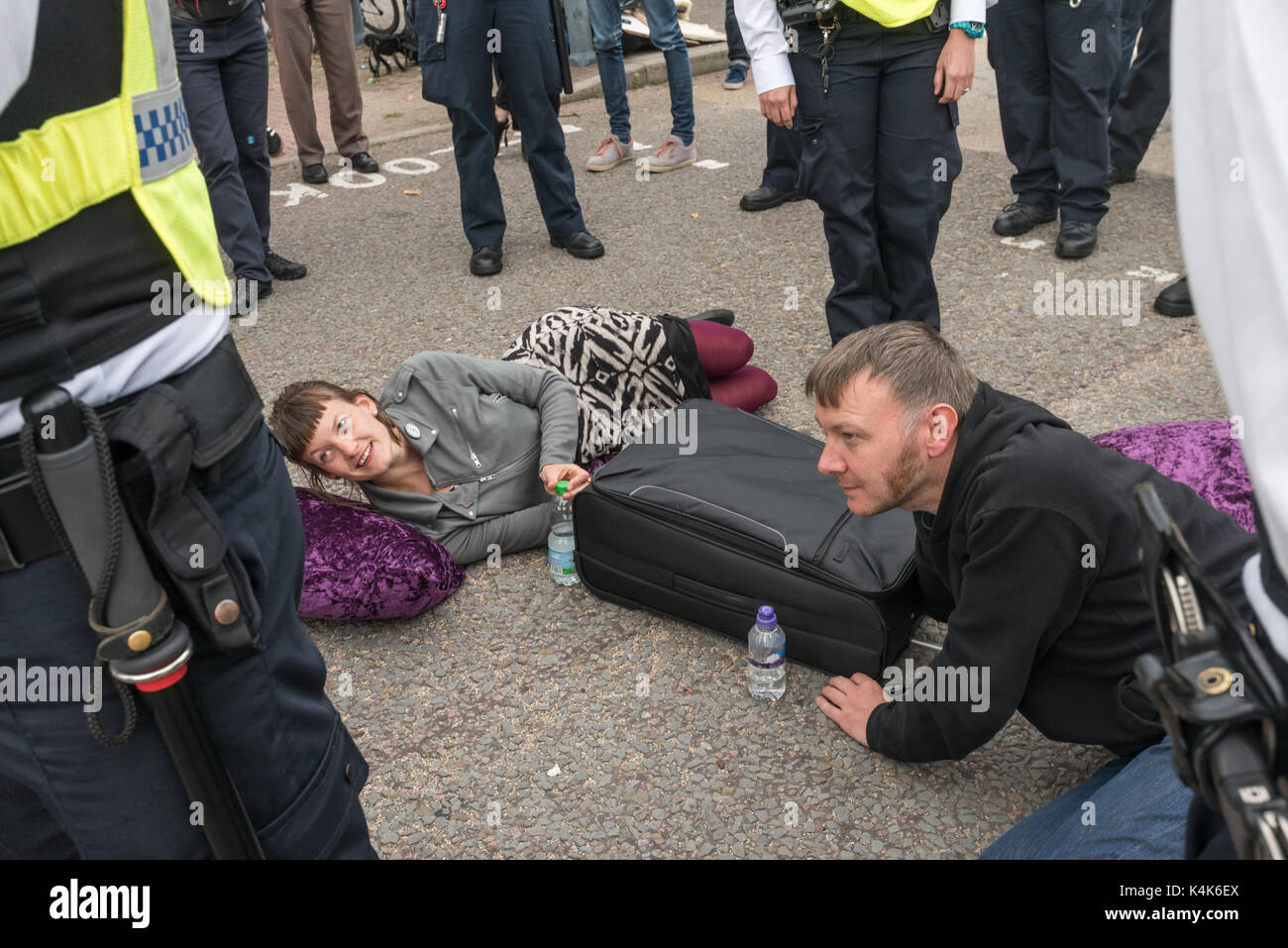 Londres, Royaume-Uni. 6 septembre 2017. Surround Police deux manifestants qui ont enfermés ensemble bloquant la route menant à la porte Est de l'ExCeL Centre. Arrêter la course aux manifestants juste effectué une série de longues lock-ins sur les routes à deux portes est et ouest le blocage de l'accès au centre ExCeL où l'on prépare pour les mondes, la plus grande foire aux armements DSEI, le Defence & Security Equipment International, soutenu par le gouvernement britannique où les fabricants d'armes et les marchands d'armes vendent des armes à tous les pays du monde, y compris de nombreux régimes répressifs. Crédit : Peter Ma Banque D'Images