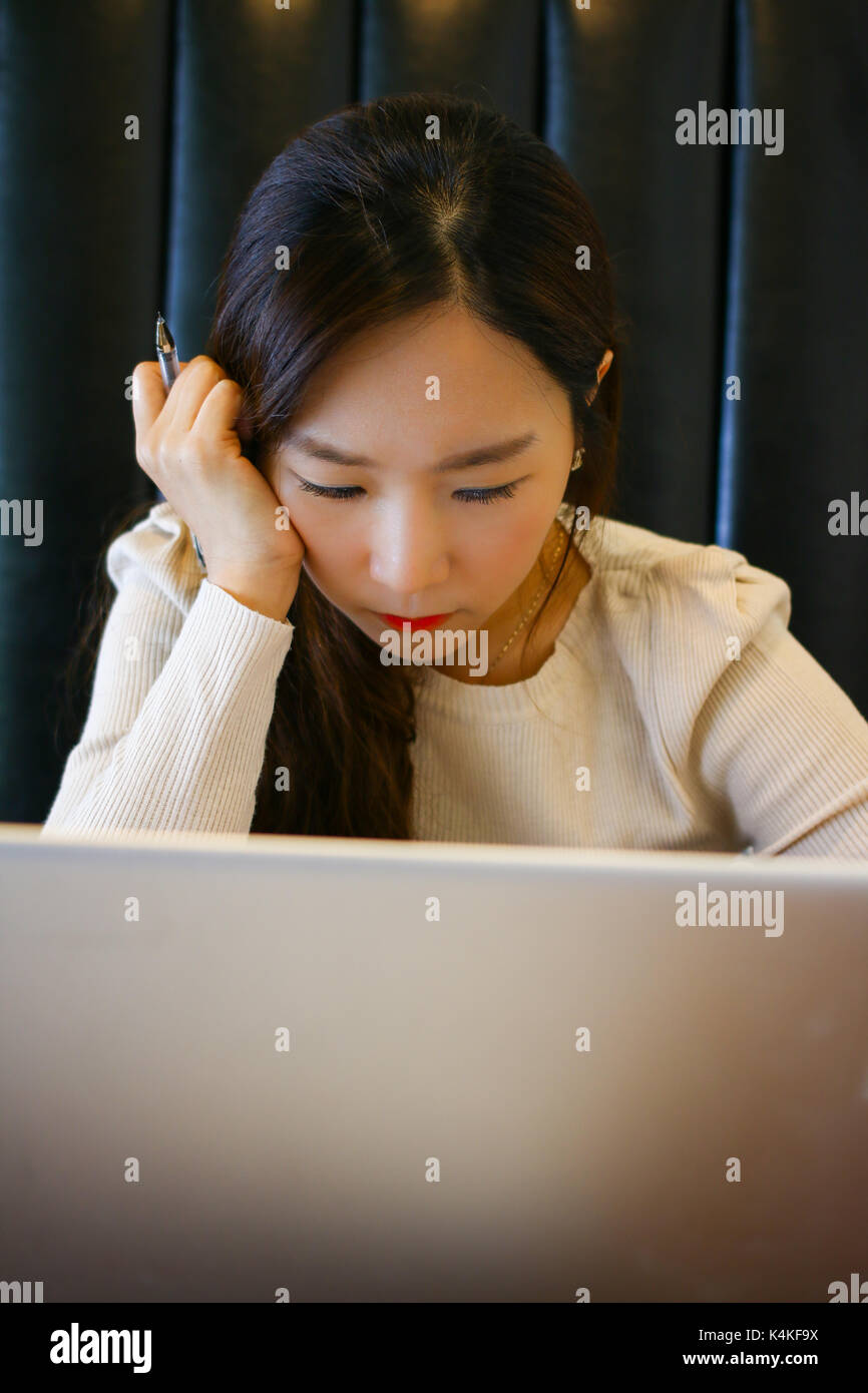 Portrait d'un asian woman using laptop in a cafe Banque D'Images