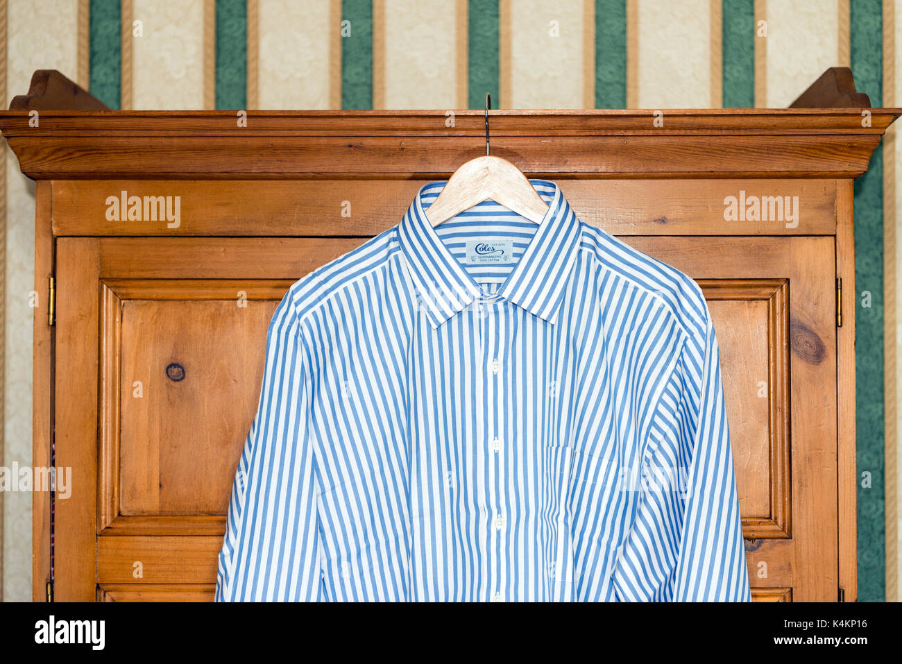 Mans shirt raccrocher sur un cintre en face d'une armoire en pin, UK. Banque D'Images