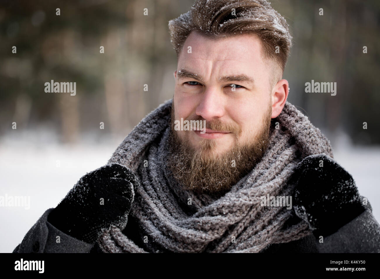 Homme élégant en hiver tenue debout dans la forêt enneigée Banque D'Images