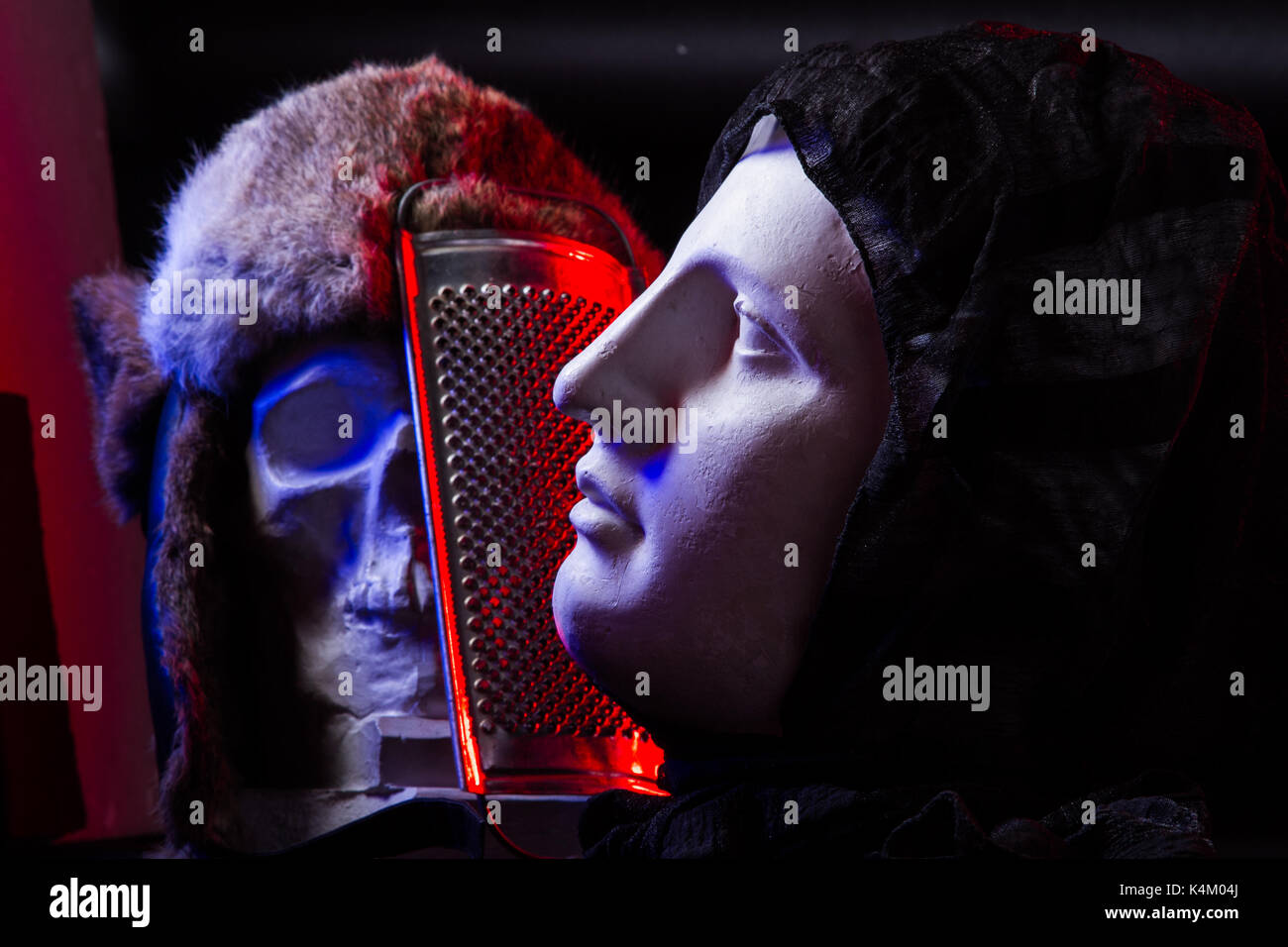 Une colorée d'un crâne artificiel et un visage de femme statue. bleu et rouge s'allume et la composition artistique studio Banque D'Images