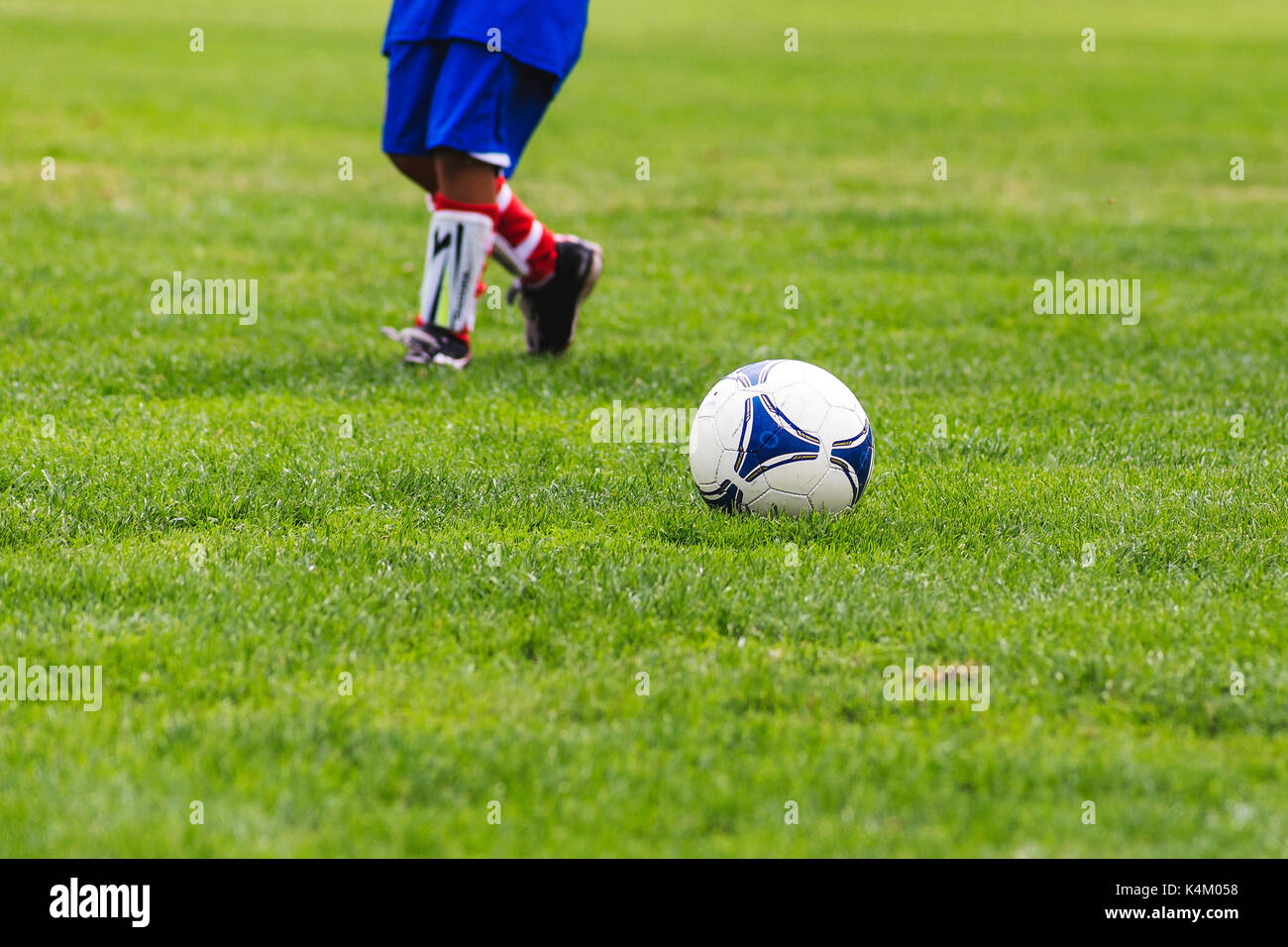 Joueur de football d'exécution pour une balle Banque D'Images