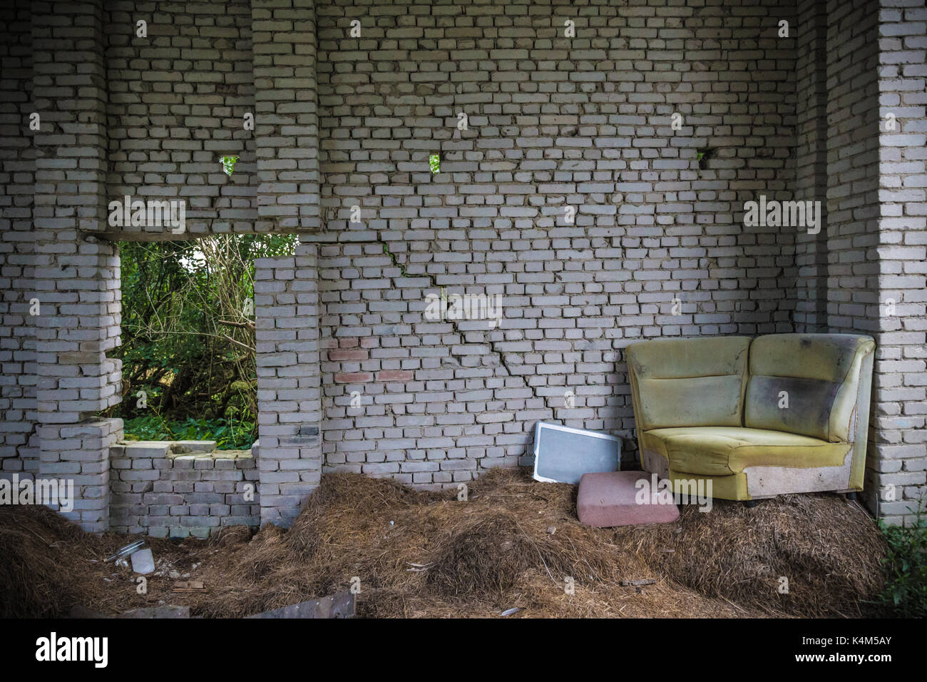 Vieux divan pourri en coin et fenêtre cassée Banque D'Images